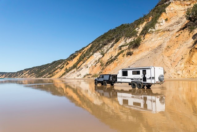 back side angle of a caravan being towed along the beach