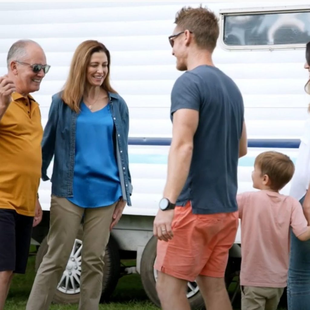group of 3 adults and one child smiling and interacting