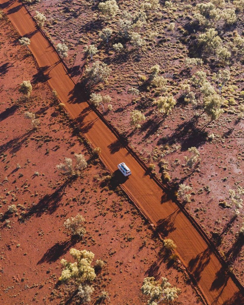 Arial view of campervan on dirt road in dessert